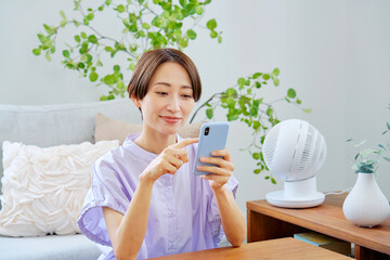 リビングでスマートフォンを使う女性
