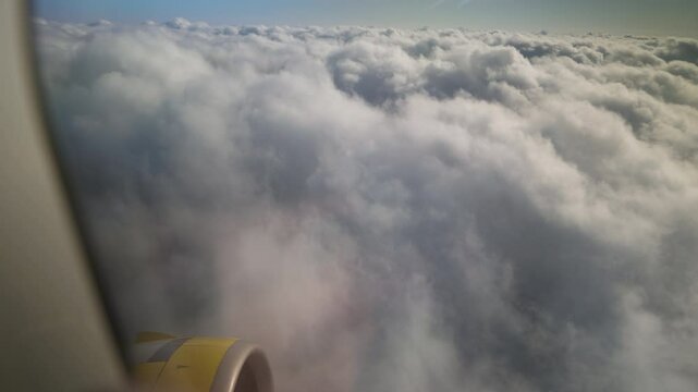 Viewing the sky on an airplane at ten thousand feet above the earth's surface, the camera slowly pushes back.