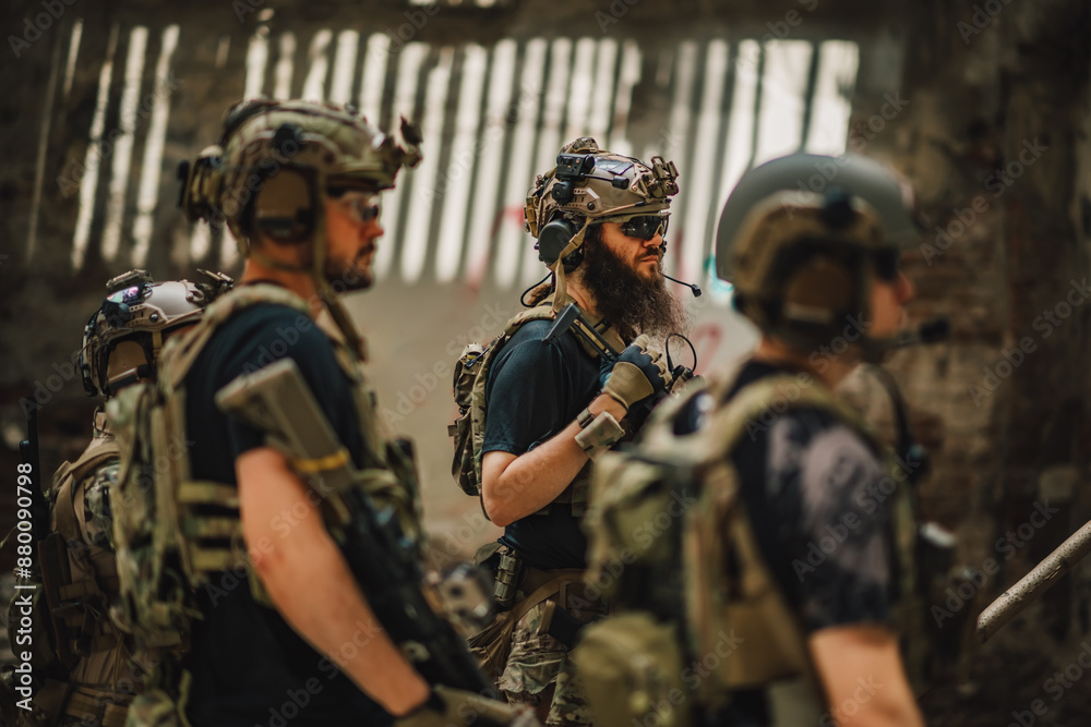 Wall mural Group of brave soldiers in abandoned building preparing for operation.