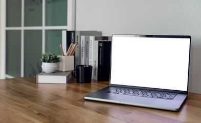 Open laptop with blank screen on a wooden desk in a kitchen room home office.