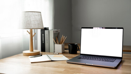 Open laptop with blank screen on a wooden desk in a kitchen room home office.