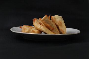 food made from thinly sliced ​​breadfruit coated in a wheat flour mixture then fried until dry and crispy. Fried breadfruit isolated on black background.