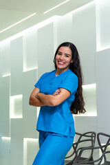 Portrait of latin hispanic female nurse or dentist using blue dentistry scrub at dental hospital. Healthcare and medicine concept.