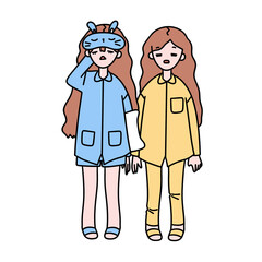 Two girls are wearing pajamas and one of them is holding the other one