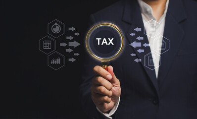 Businessman analyzing tax data with digital interface and magnifying glass.