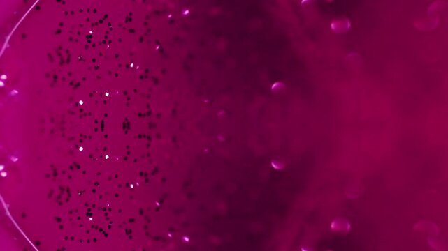 Shimmering liquid. Abstract background. Glitter lacquer flow. Blur sparkling particles polish emulsion purple fluid symmetrical motion on surface.