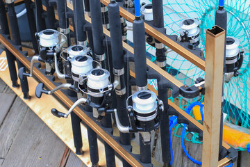 Angler tackle sets of spinning rods with reels and spools of fishing lines and retrieval nets