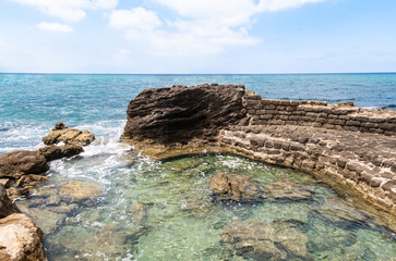 Remains  of stone pier of the cargo port on the shores of Mediterranean Sea in Caesarea fortress in the north of Israel