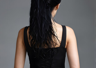 Naklejka premium A woman with long black hair is wearing a black tank top
