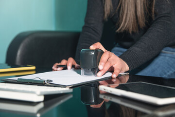 Business woman using stamp on document.