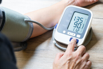 Man checks blood pressure monitor and heart rate monitor with digital pressure gauge. Health care and Medical concept.	
