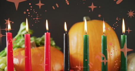 Obraz premium Image of orange stars over kwanzaa candles and pumpkins