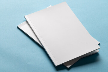 Blank white books on a blue background, with copy space