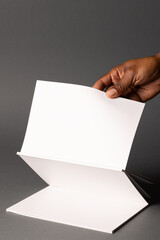 African American man holding a blank brochure, with copy space