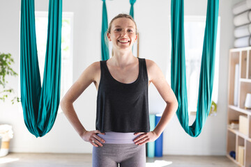 Portrait of happy caucasian teenage girl smiling at aerial yoga class