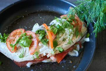 Raw salmon with tomatoes and dill in a skillet. Dinner preparation.