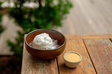 Coconut Ice Cream in a Wooden Bowl with Caramel Sauce