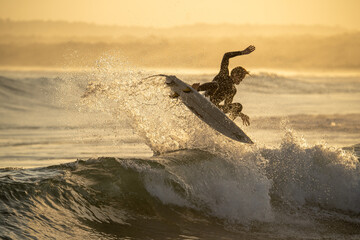A surfer silhouette caught during golden hour