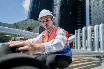 Male engineer inspects air and water pipelines in the engineering system area of ​​the factory...