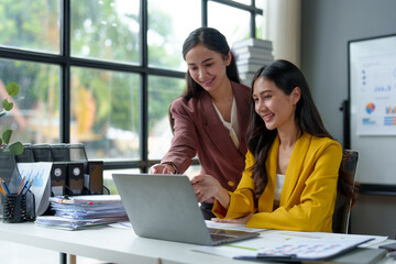 Two young businesswomen exchange ideas, presenting and analyzing marketing and investment plans on files. Discuss startup project ideas. Analyze planning and financial statistics at the office.