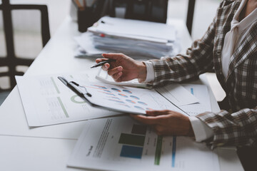 Beautiful Asian businesswoman or female secretary is working on a laptop computer. Analyze plans on financial files. Her online marketing in the office modern technology concept.