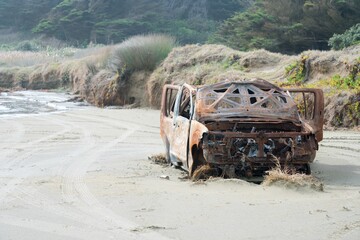 abandoned burned out car in the sand dunes