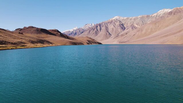 4K aerial shot of blue color Chandra Taal lake with Himalaya mountains in Spiti Valley, India. Beautiful aerial landscape of mountain lake. Travel, vacation and Holidays background.