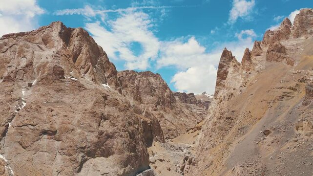 4K Aerial view of Dry Rocky Rugged Mountains at Ladakh, India. Dirt road passing through mountains. Nature landscape and adventure travel concept. 