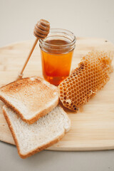 Fresh honey styled with honey dipper, toast, and honeycomb