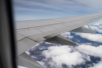 Obraz premium looking out plane window at the clouds above australia over the wing