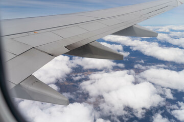 looking out plane window at the clouds above australia over the wing