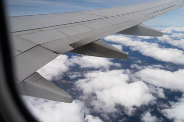 looking out plane window at the clouds above australia over the wing