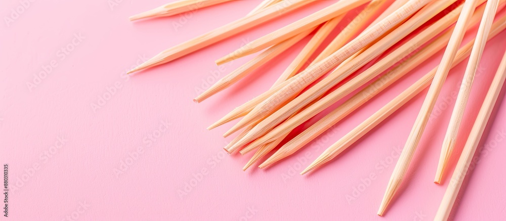 Poster toothpicks made of wood placed on a pink backdrop with copy space image.