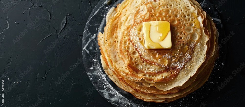 Poster Top view of a stack of crepes with butter on a marble board against a black background, featuring copy space image.