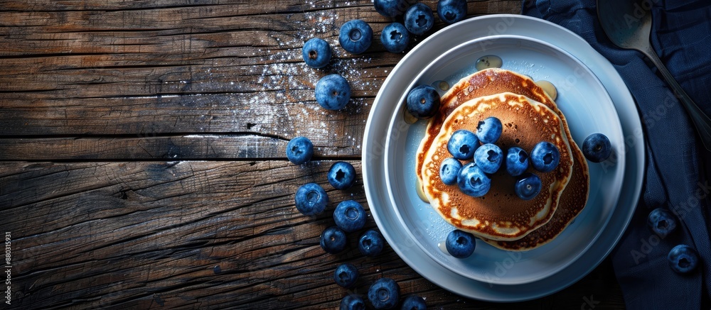 Poster breakfast featuring pancakes and blueberries set on a dark wooden table with available copy space im