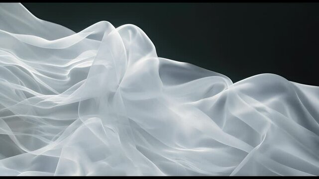 A white fabric with a black background. The fabric is flowing and has a sense of movement