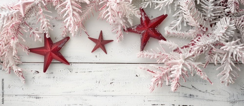 Poster on a white wooden surface, a festive display features a light pink garland with two red stars, creat