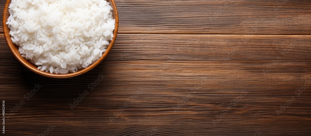 Aufkleber top view image of a bowl of cooked rice on a wooden background with ample copy space for text or gra