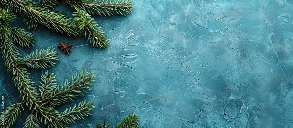 Aufkleber Christmas themed background with green fir branches on a textured blue surface ideal for adding text copy space image