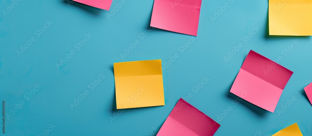 Poster blue background with yellow and pink square blank paper stickers offering a copy space image