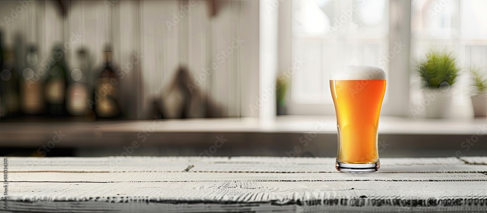 Poster beer with foam in a glass on a white wooden bar top with room for a copy space image