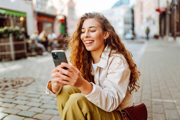 Happy woman with phone, text messaging on summer vacations on the street city. Travel, blogging, weekend, relax and lifestyle concept. © maxbelchenko