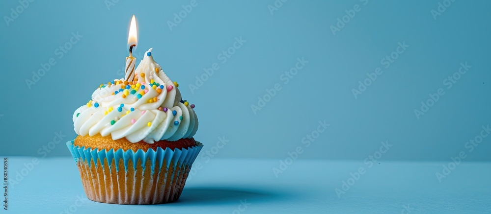 Aufkleber A birthday cupcake sits atop a blue background featuring a lit candle leaving room for text in an image. with copy space image. Place for adding text or design