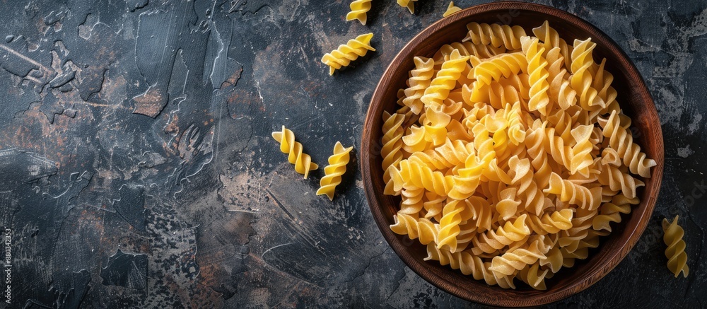 Poster Top view of uncooked Creste di Gallo pasta presented in a wooden bowl on a dark vintage backdrop with room for text or other graphics in the image. with copy space image