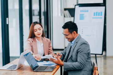 group of four happy young asian corporate people teammates meeting discussing business in office.