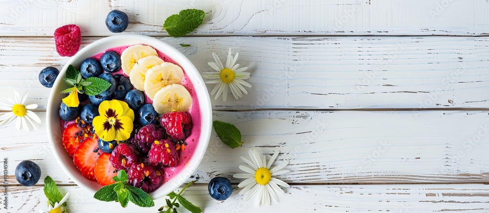 Poster top down view of a delectable smoothie bowl adorned with fresh fruits blueberries and flowers placed