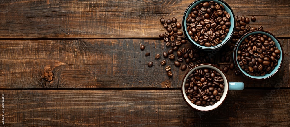 Poster coffee mugs roasted beans on a wooden table with a copy space image for the background in a flat lay