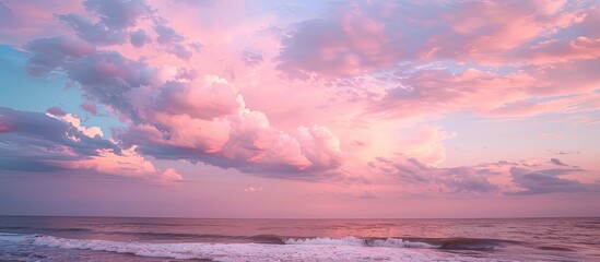 Fototapeta premium Peaceful seascape at dusk with pink tones in the sky and dramatic clouds perfect as a copy space image
