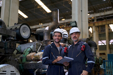 Engineer is working at train machine part factory.