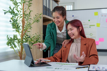 Obraz premium Analysis. Discussion. Asian female economist and marketer pointing at financial data sheet to plan company's financial growth. Negotiation. Expressing ideas. Successful teamwork concept.